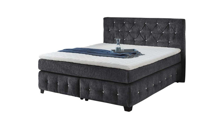 Boxspringbett Xin Max mit einem Stoffbezug aus schwarzem Chenille und Glitzersteinchen im Kopfteil und den Boxen