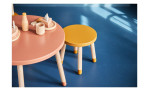 Detailausschnitt von Kinderhocker Dots in senfgelb mit holzfarbenen Beinen.