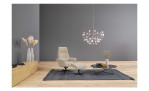 Komfort-Fernsehssel in der Farbausführung Beige / Braun mit einem Hocker, in einen Raum stehend