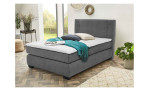 Boxspringbett Felina mit einem Bezug in der Farbe Dunkelgrau und einem weißen Topper, Milieubild