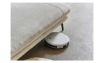 Detailfoto mit einem Staub-Roboter, der unter dem Sofa fährt