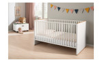 Babybett Lieven in der Farbausführung Kreideweiß und Eiche Nebraska in einem Raum stehend
