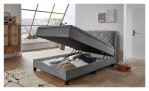 Boxspringbett Josh in einem silberen Bezug in mikrofaser und schwarzen füßen. Mit geöffneten Bettkasten.