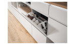 Schuhschrank Shoes mit 3 Klappen und 1 Schubkasten, in der Farbe Weiß und einem Oberboden in Nox Oak Nachbildung, Detailansicht mit geöffneter Klappe