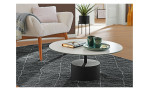 Couchtisch MONDO Varium mit einer Glas-Keramik Tischplatte in Marmoroptik Weiß mit einem schwarzem Stahlgestell. Auf einem dekorierten HIntergrund.