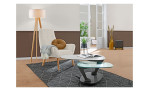 Couchtisch MONDO Varium mit einer Glas-Keramik Tischplatte in Marmoroptik Weiß und einer Klarglas Tischplatte und einem schwarzem Metallgetsell. Auf einem dekoreirten Hintergrund.