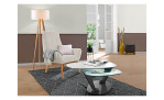 Couchtisch MONDO Varium mit einer Glas-Keramik Tischplatte in Marmoroptik Weiß und einer Klarglas Tischplatte und einem schwarzem Metallgetsell. Auf einem dekoreirten Hintergrund.