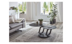 Couchtisch MONDO Varium mit zwei Glas-Keramik Tischplatten in Titan mit einem scwarzem Gestell. Auf einem dekorierten Hintergrund.