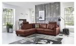 Basis-Ecksofa MONDO Maestra in einem Echtlederbezug in der Farbe Cognac. Auf einem dekorierten Hintergrund