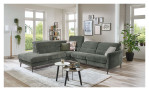 Komfort-Ecksofa MONDO Mimas in einem Stoffbezug in Moos. Auf einem dekorierten Hintergrund