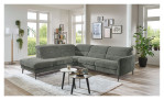 Basis-Ecksofa MONDO Mimas in einem Stoffbezug in Moos. Auf einem dekorierten Hintergrund