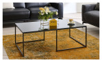 Couchtisch MONDO Garta mit einer schwarz hochglanz Glasplatte und einem schwarzem Metallgestell. Auf einem dekorierten Hintergrund