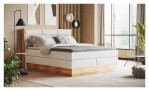 Boxspringbett VALMONDO Incana in einem Stoffbezug in Cream und einem Sichtholzrahmen in Eiche. Auf einem dekorierten Hintergrund