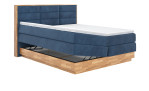 Boxspringbett VALMONDO Incana in einem Stoffbezug in Dark Blue und einem Sichtholzrahmen in Eiche. Mit geöffneten Bettkasten