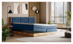 Boxspringbett VALMONDO Incana in einem Stoffbezug in Dark Blue und einem Sichtholzrahmen in Eiche. Auf einem dekorierten Hintergrund