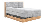 Boxspringbett VALMONDO Incana in einem Stoffbezug in Stone und einem Sichtholzrahmen in Eiche. Mit geöffneten Bettkasten