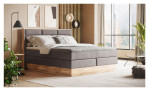 Boxspringbett VALMONDO Incana in einem Stoffbezug in Taupe und einem Sichtholzrahmen in Eiche. Auf einem dekorierten Hintergrund