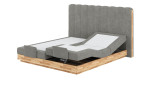 Boxspringbett VALMONDO Incana in einem Stoffbezug in Sand und einem Sichtholzrahmen in Eiche. Mit gezeigter motorischen Verstellung