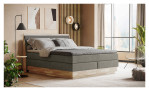 Boxspringbett VALMONDO Incana in einem Stoffbezug in Hunter und einem Sichtholzrahmen in Eiche. Auf einem dekorierten Hintergrund