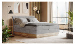 Boxspringbett VALMONDO Incana in einem Stoffbezug in Taupe und einem Sichtholzrahmen in Eiche. Auf einem dekorierten hintergrund