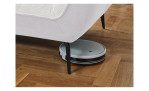 Detailfoto von der Höhe der Füße, mit einem Staubsaug-Roboter