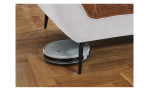 Detailfoto von der Höhe der Füße, mit einem Staubsaug-Roboter