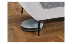 Detailfoto von der Höhe der Füße, mit einem Staubsaug-Roboter