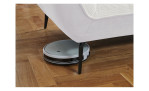 Detailfoto von der Höhe der Füße, mit einem Staubsaug-Roboter