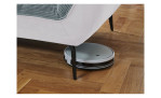 Detailfoto von der Höhe der Füße, mit einem Staubsaug-Roboter