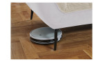 Detailfoto von der Höhe der Füße, mit einem Staubsaug-Roboter