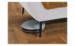 Detailfoto von der Höhe der Füße, mit einem Staubsaug-Roboter