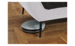 Detailfoto von der Höhe der Füße, mit einem Staubsaug-Roboter