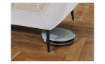 Detailfoto von der Höhe der Füße, mit einem Staubsaug-Roboter