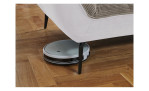 Detailfoto von der Höhe der Füße, mit einem Staubsaug-Roboter