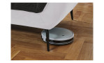 Detailfoto von der Höhe der Füße, mit einem Staubsaug-Roboter
