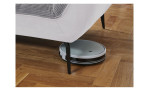 Detailfoto von der Höhe der Füße, mit einem Staubsaug-Roboter