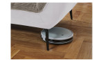 Detailfoto von der Höhe der Füße, mit einem Staubsaug-Roboter