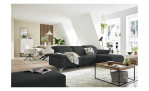 Komfort - Ecksofa Musterring MR 370, in der Farbausführung stone mit einem Hocker, in einem Raum stehend