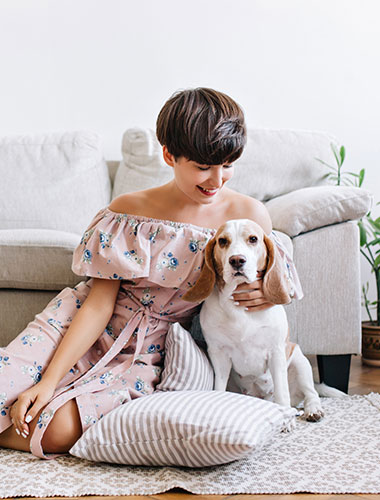 Frau und Hund sitzen vor einem Sofa Frau und Hund sitzen vor einem Sofa