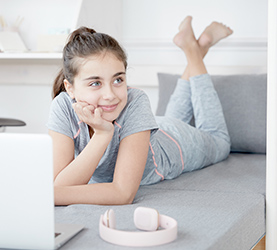 Kind am Laptop auf Sofabett Kind am Laptop auf Sofabett